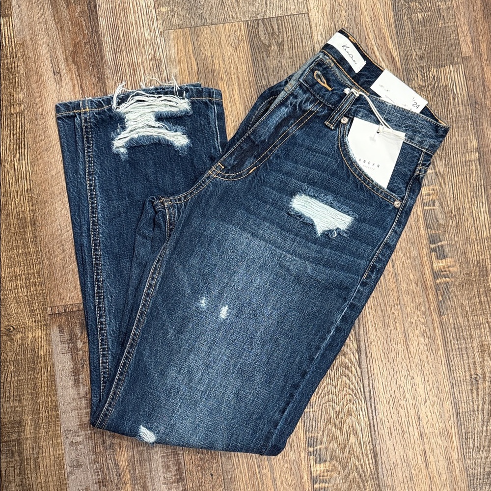 Distressed, never worn, not boot cut but wider at ankle